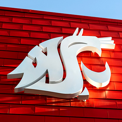 A white WSU logo against the red exterior of a building.